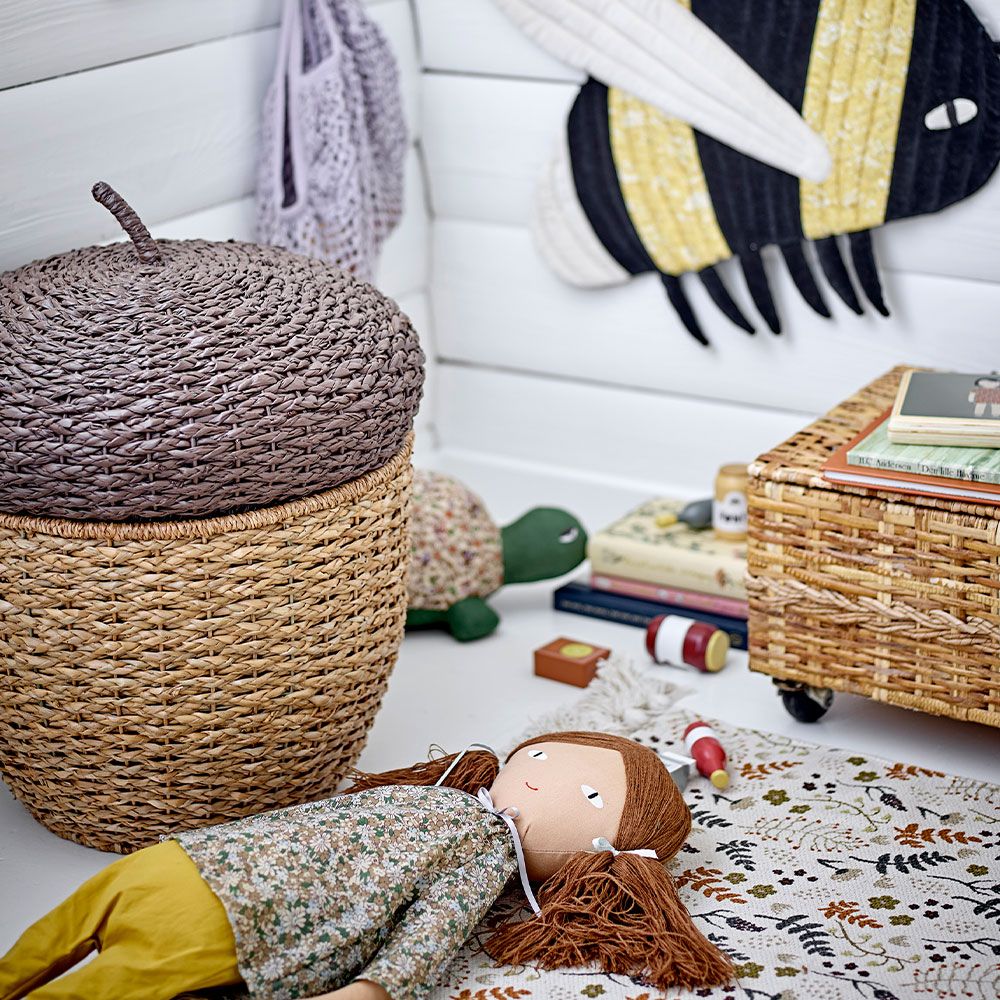 A children's storage basket which resembles an acorn with a natural seagrass and rattan finish