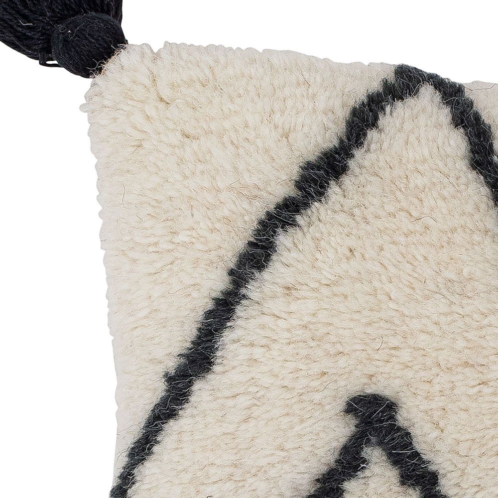 A beautiful black and white cushion with a geometric design and stylish tassel details