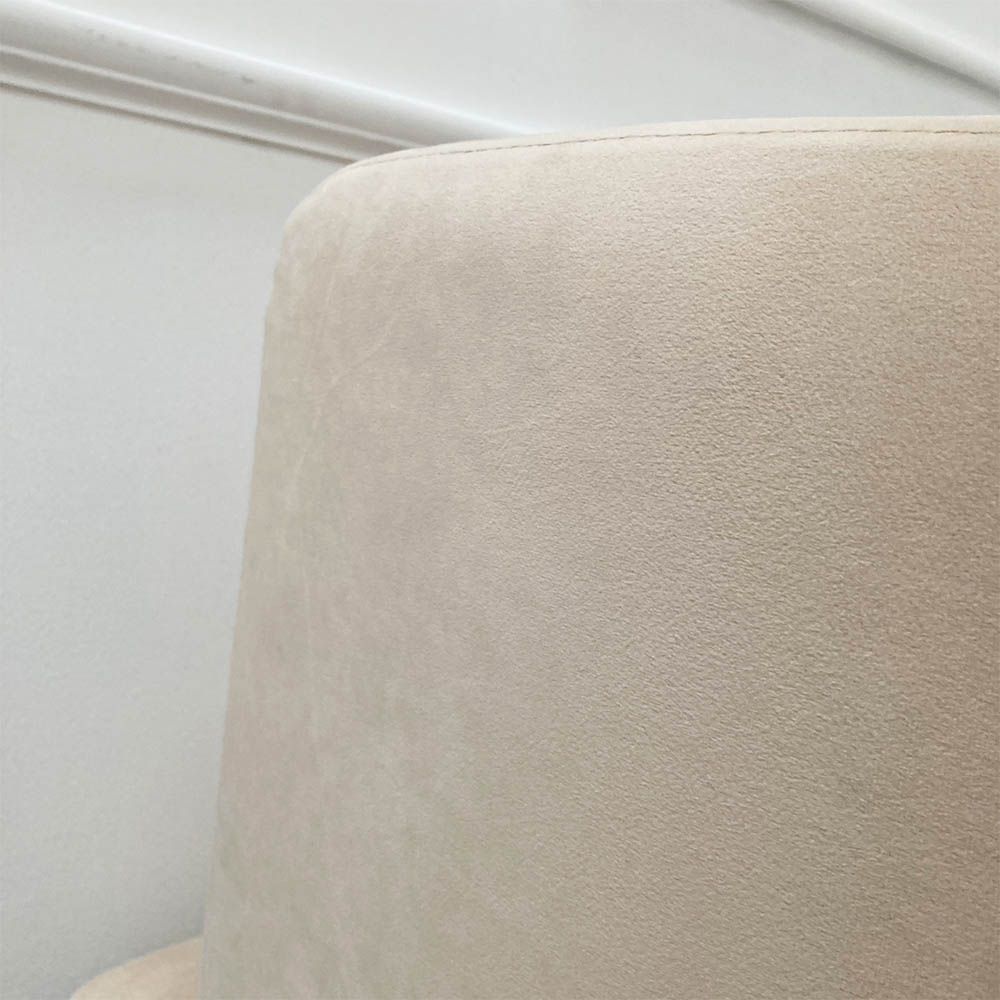 A luxurious linen mid-century inspired armchair with slender iron legs and beige velvet upholstery