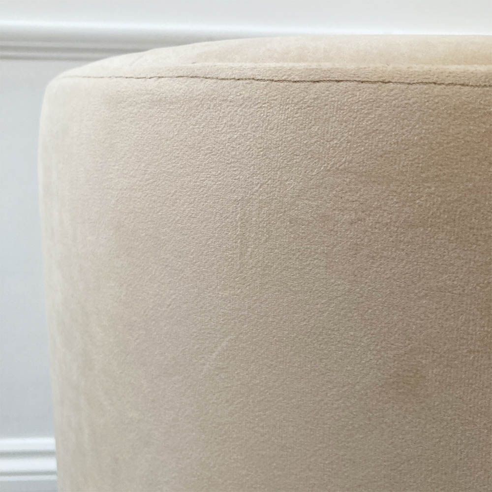A luxurious linen mid-century inspired armchair with slender iron legs and beige velvet upholstery