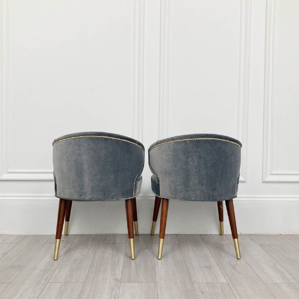 A sumptuous blue-grey velvet dining chair with hand-applied studs