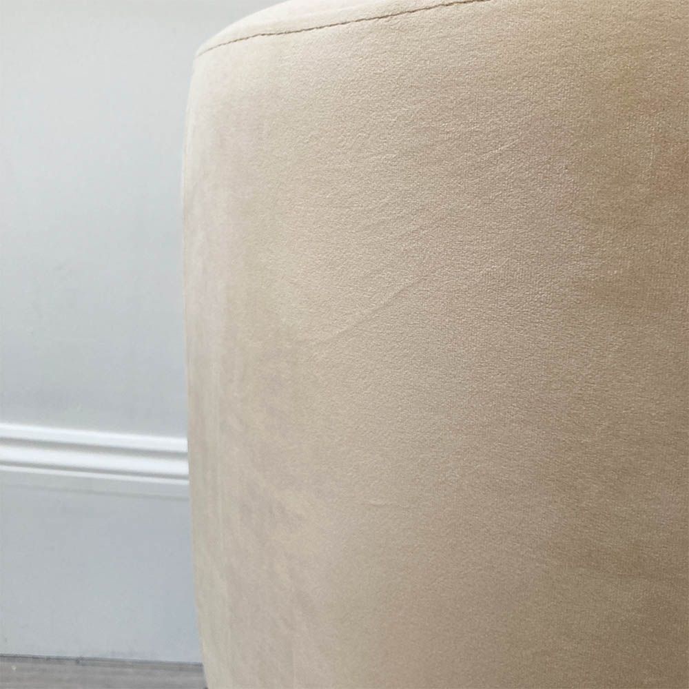A luxurious linen mid-century inspired armchair with slender iron legs and beige velvet upholstery