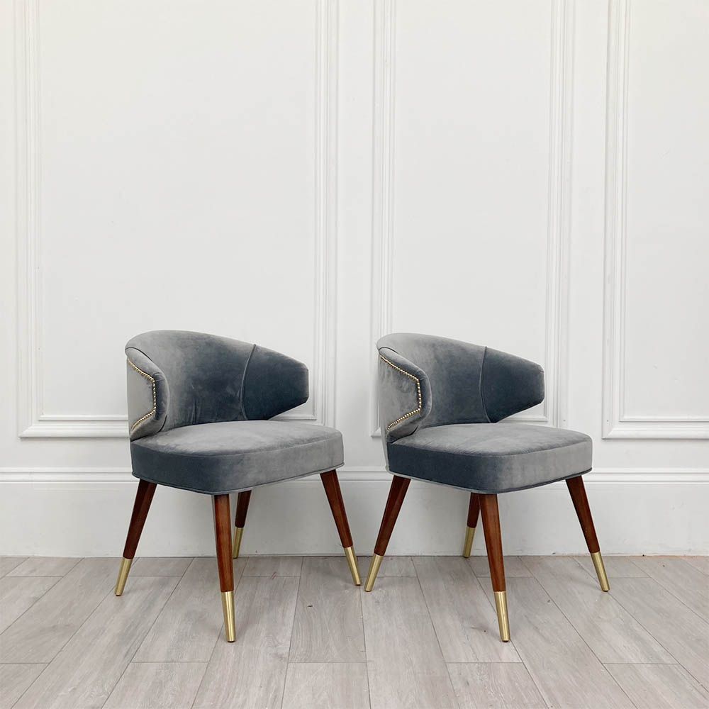 A sumptuous blue-grey velvet dining chair with hand-applied studs
