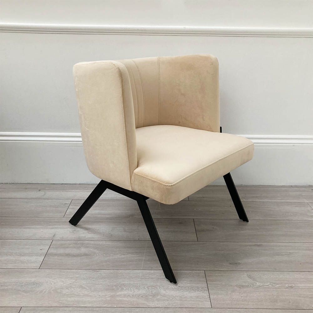 A luxurious linen mid-century inspired armchair with slender iron legs and beige velvet upholstery