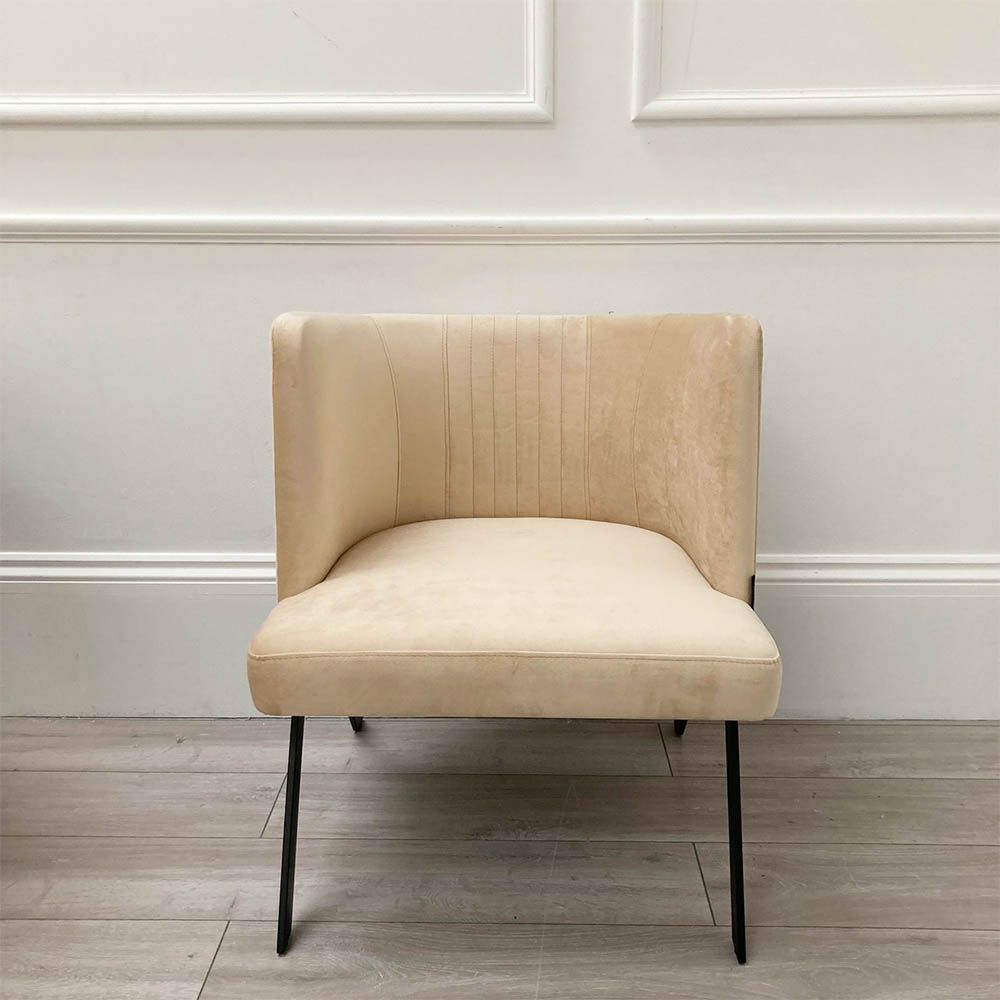 A luxurious linen mid-century inspired armchair with slender iron legs and beige velvet upholstery