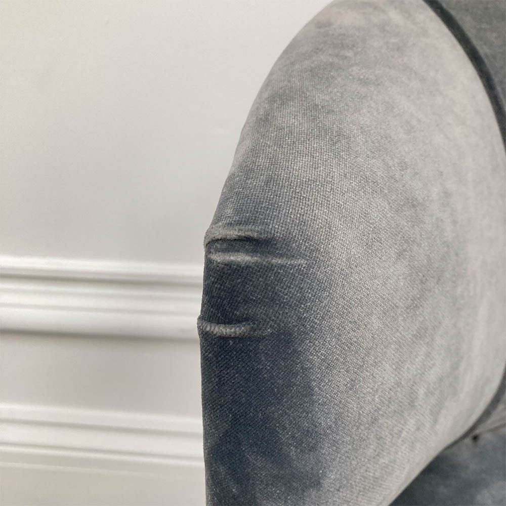 A sumptuous blue-grey velvet dining chair with hand-applied studs