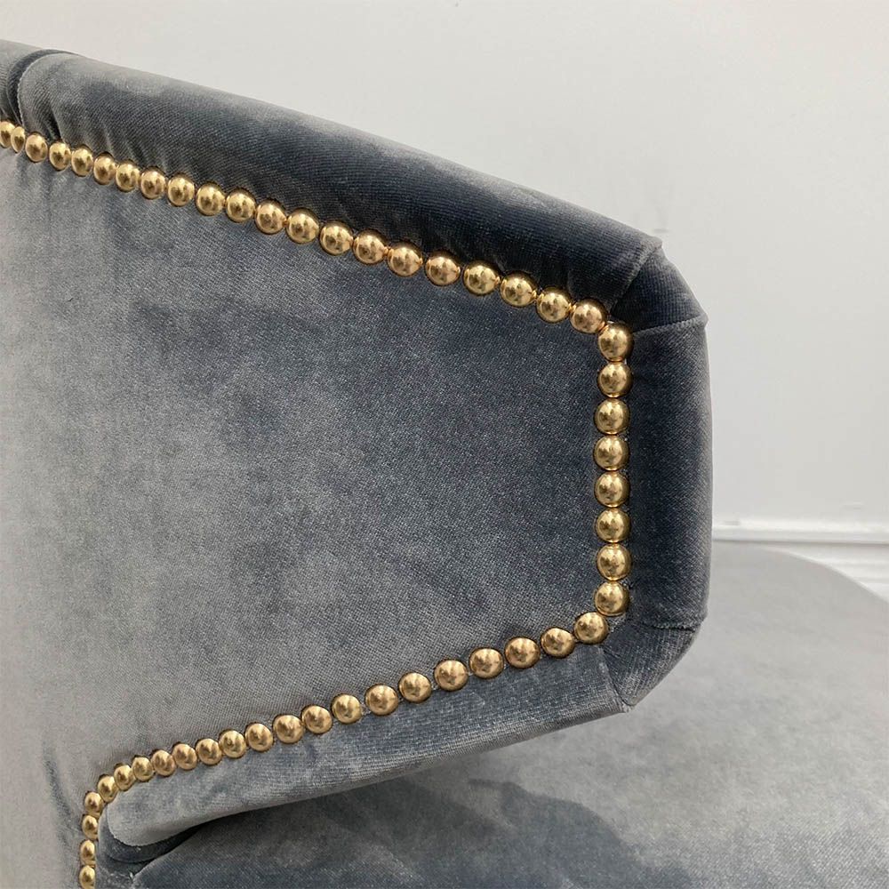 A sumptuous blue-grey velvet dining chair with hand-applied studs