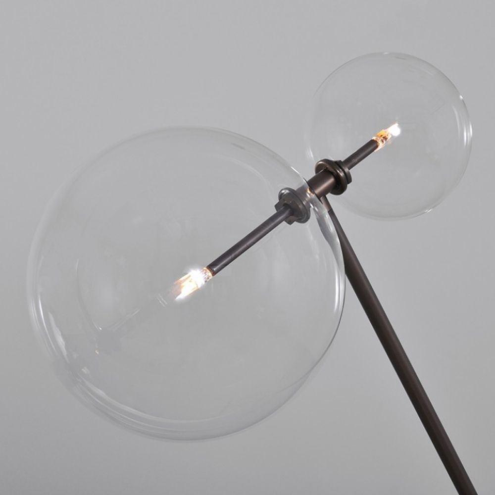 Black gunmetal brass industrial style floor lamp with angled, adjustable frame and clear glass globe lampshades