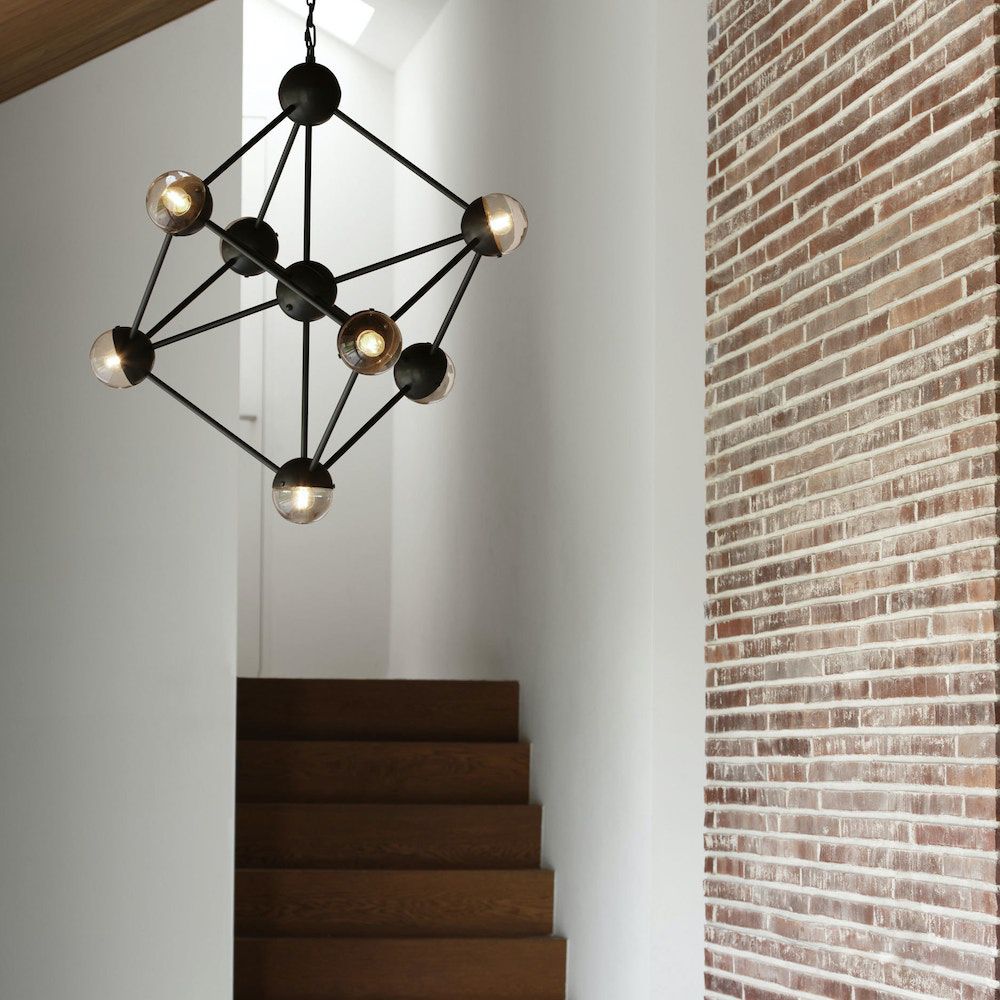 An industrial style chandelier by Schwung with a geometric design, seven transparent glass shades and a black gunmetal 