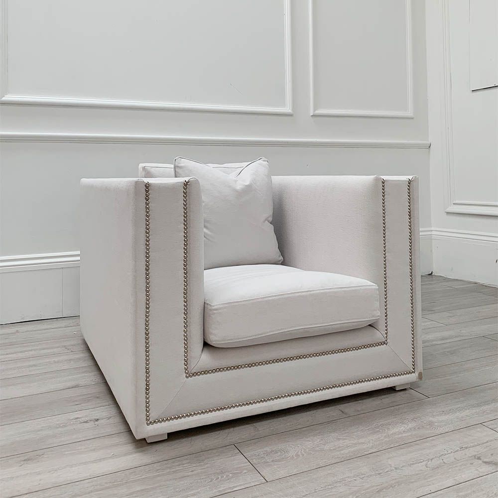 Boxy armchair with sumptuous grey mist upholstery and glamorous studding details 