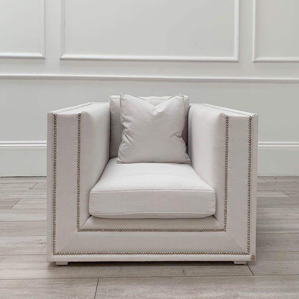Boxy armchair with sumptuous grey mist upholstery and glamorous studding details 