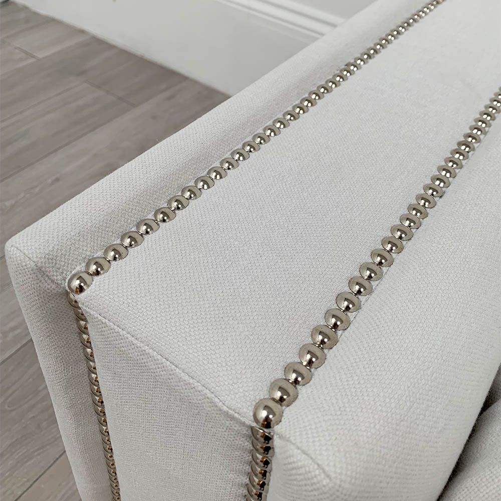 Boxy armchair with sumptuous grey mist upholstery and glamorous studding details 