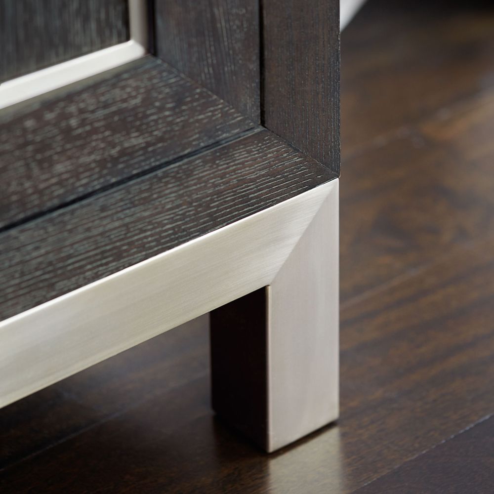 An elegant three door sideboard with a dark brown wooden finish and stylish stainless steel accents