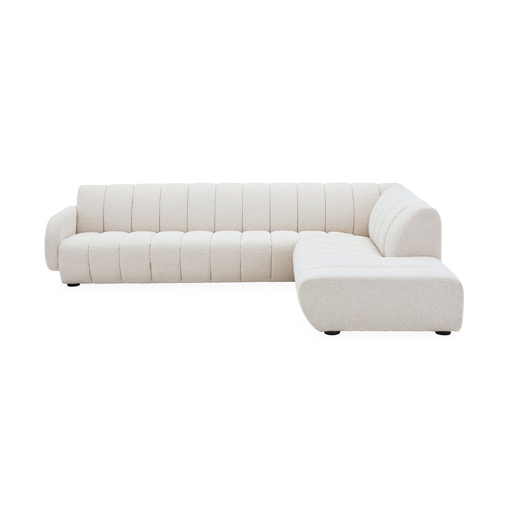 A sumptuous sectional sofa by Jonathan Adler upholstered in an Olympus Ivory bouclé with stylish deep channelled cushions and capsule-shaped arms