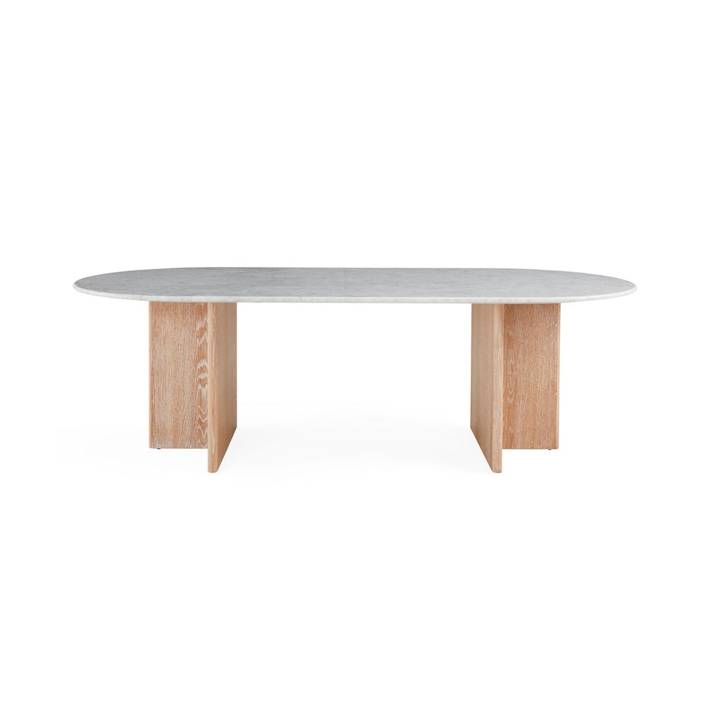 A luxurious dining table by Jonathan Adler with a white Carrara marble top and T-shaped legs crafted from solid oak 