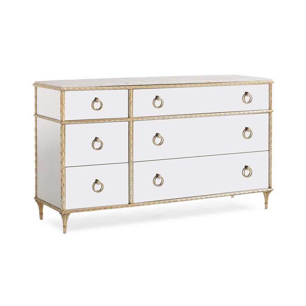 A luxurious mirrored dresser/chest of drawers with antique detailing and a champagne finish
