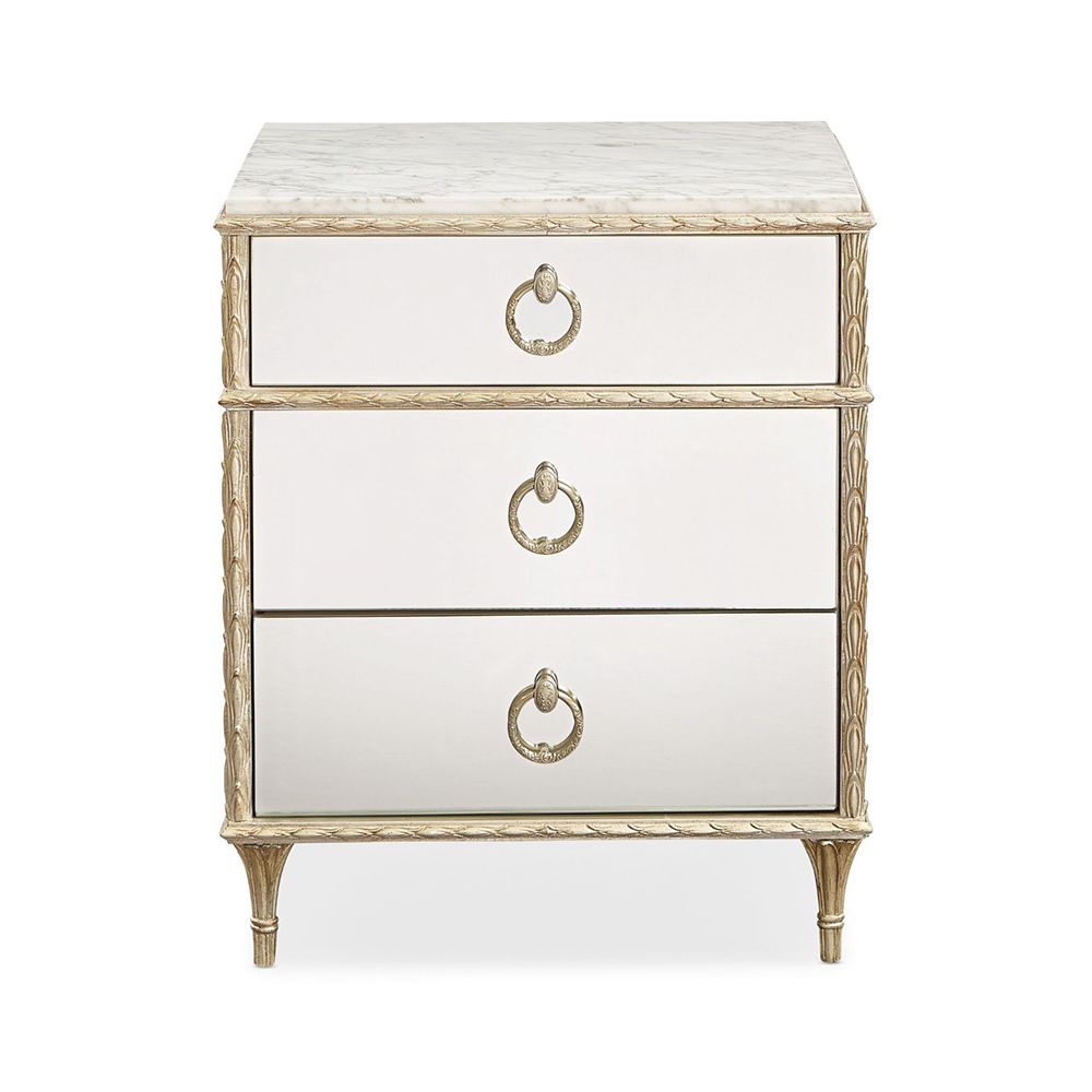 A luxury bedside table with a mirrored design, white marble top and glamorous gold detailing