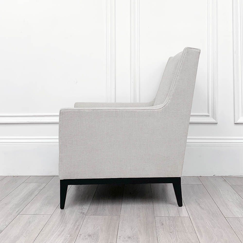 A gorgeous armchair with a wooden base and mid-century undertones