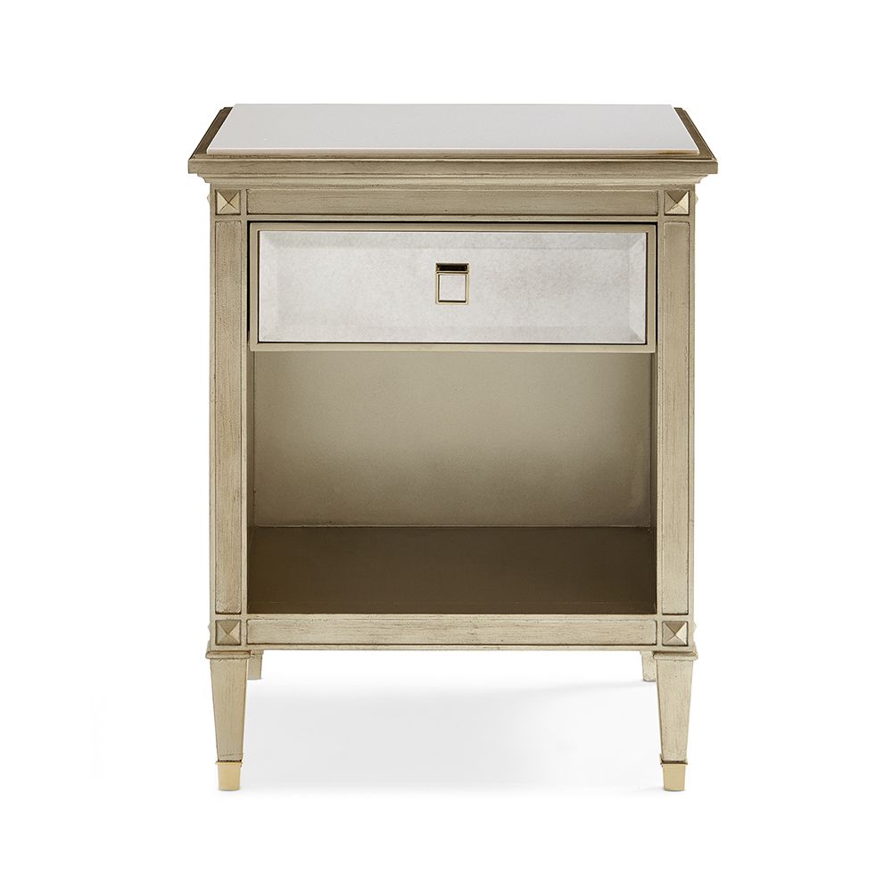 A glamorous bedside table with an antique mirrored design and champagne finish