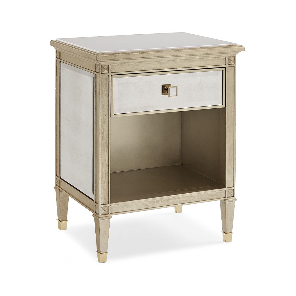 A glamorous bedside table with an antique mirrored design and champagne finish