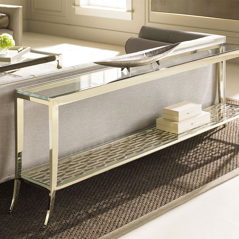 Glamorous console table with sleek glass surface and shelf and metal patterning 