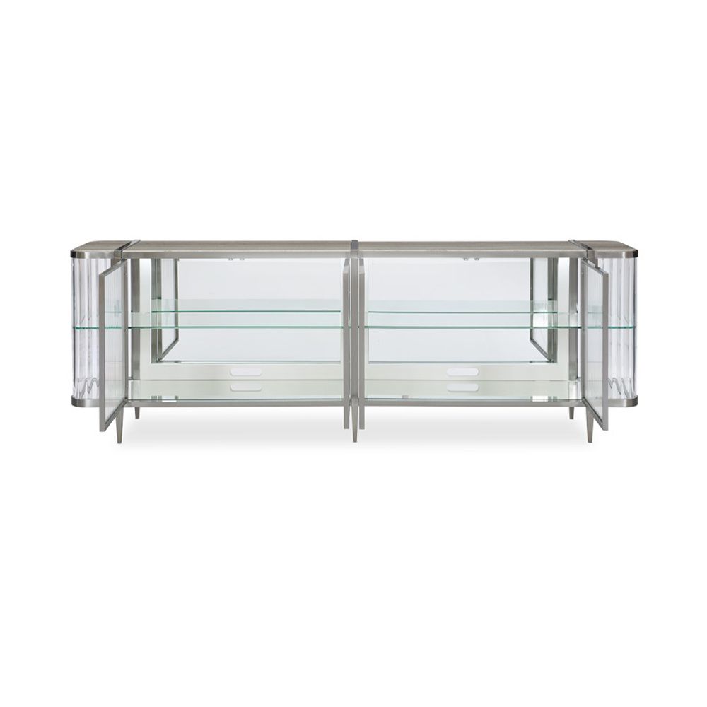 A contemporary console table by Caracole with clear, wave-effect acrylic doors and a mirrored interior