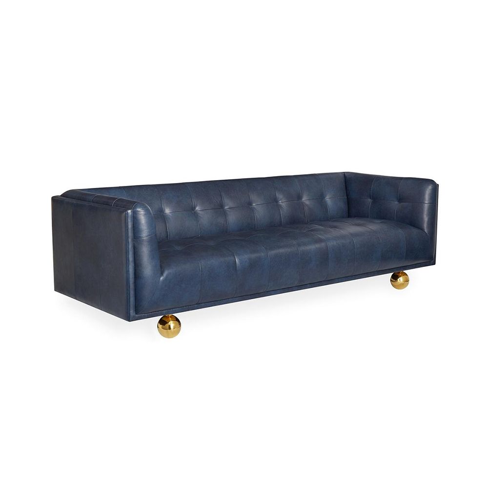 A luxurious modern sofa with navy leather upholstery and brass feet 