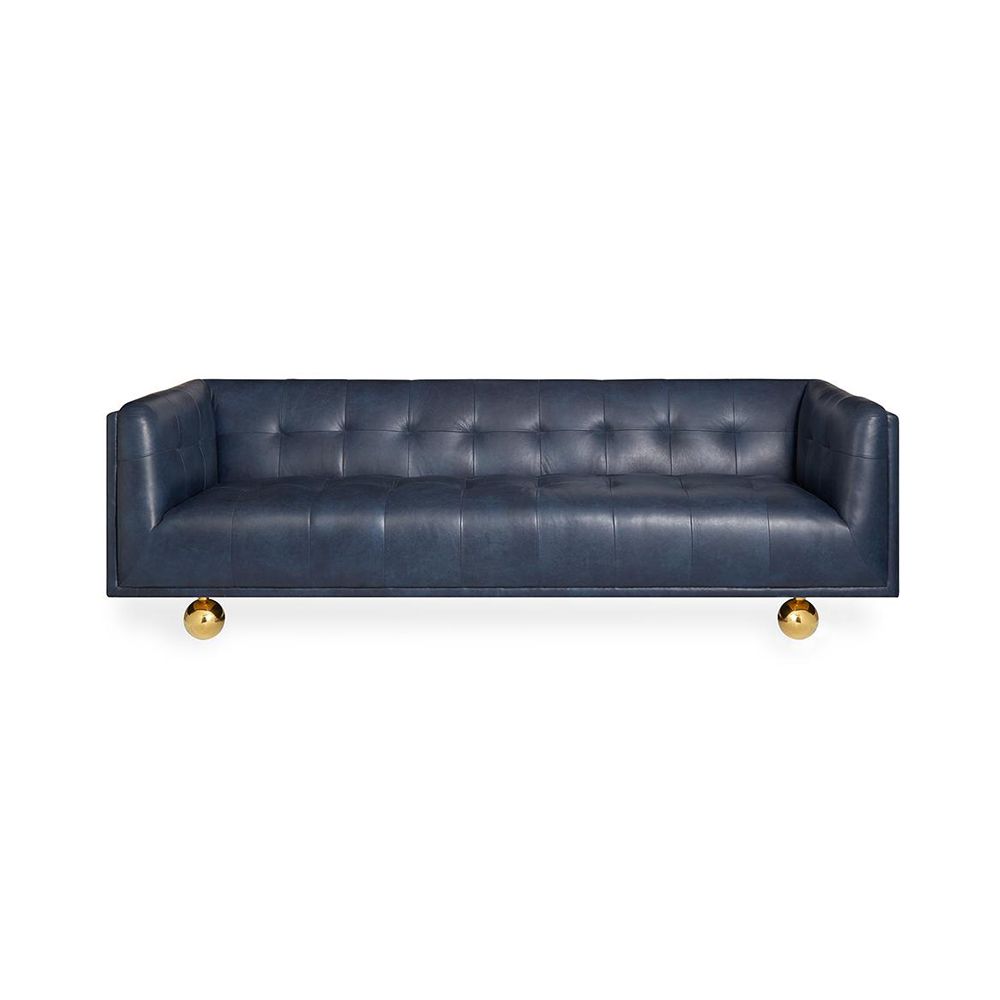 A luxurious modern sofa with navy leather upholstery and brass feet 