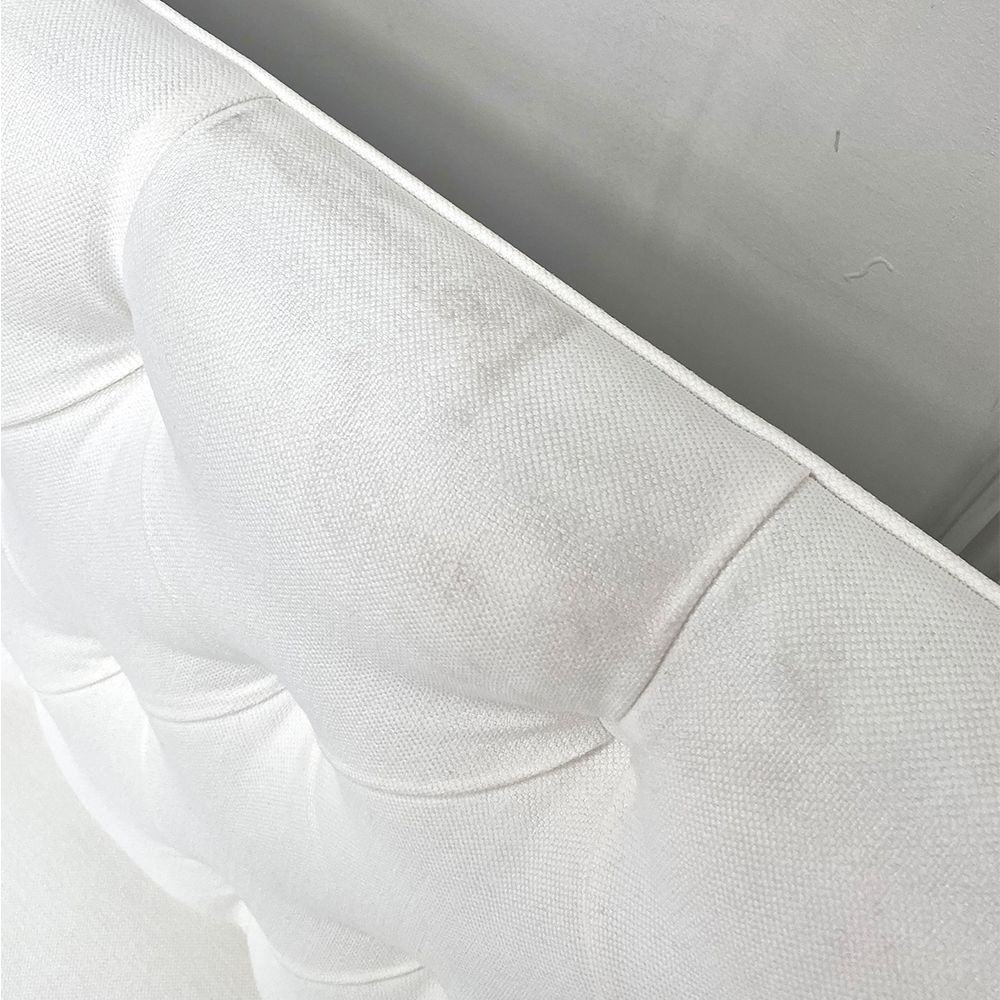 A luxurious linen-upholstered bench with white legs