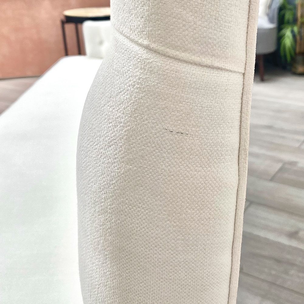 A luxurious linen-upholstered bench with white legs