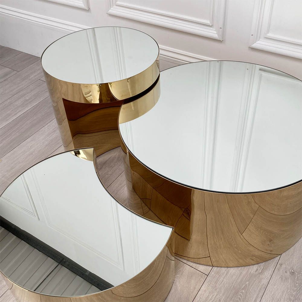 Glamorous set of three tables with mirrored tops and polished brass bases
