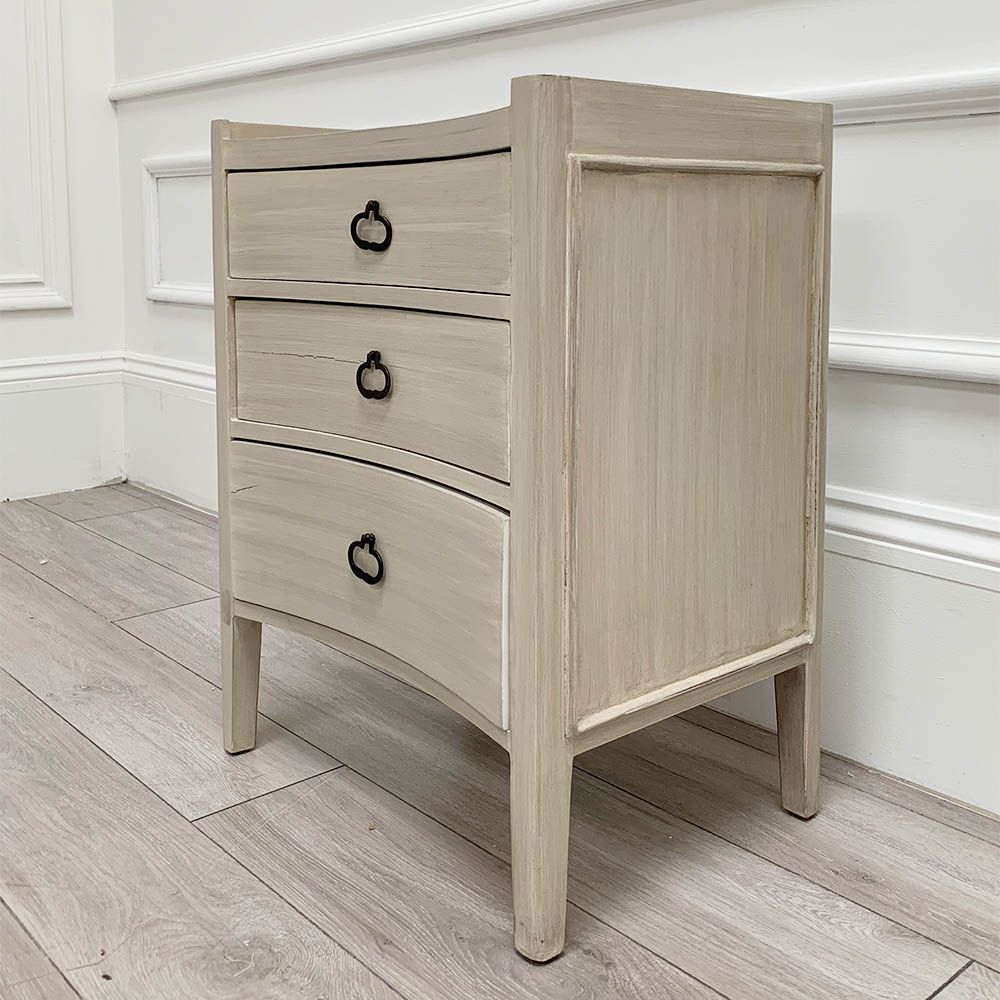 White washed three door bedside cabinet with some splits to the wood. 