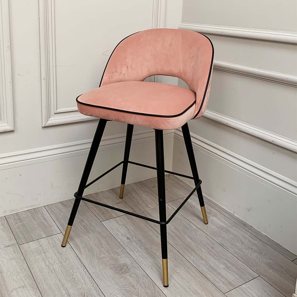 A pair of pink velvet mid-century counter stool with black faux leather piping and golden feet caps