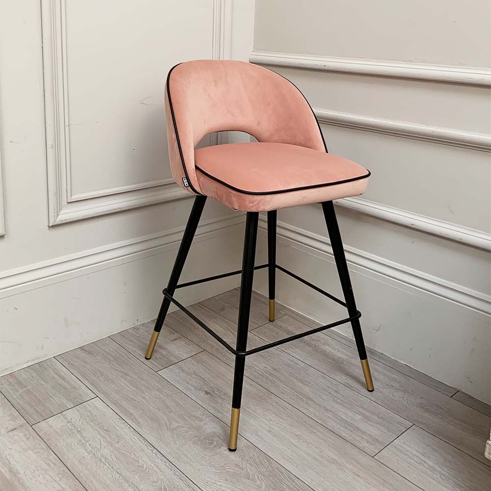 A pair of pink velvet mid-century counter stool with black faux leather piping and golden feet caps