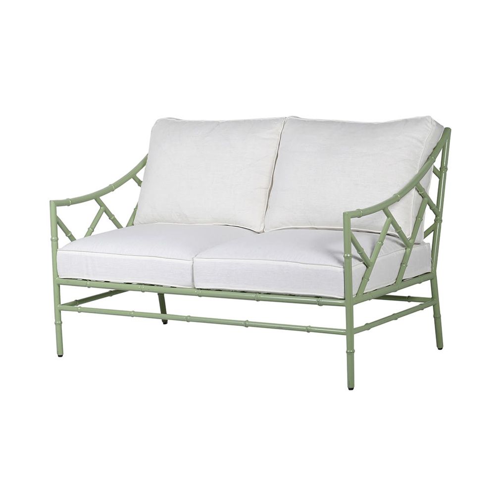 A stylish sage green outdoor two seater sofa with white cushions