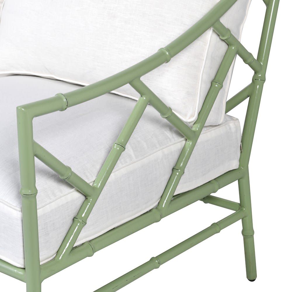 A stylish sage green outdoor two seater sofa with white cushions