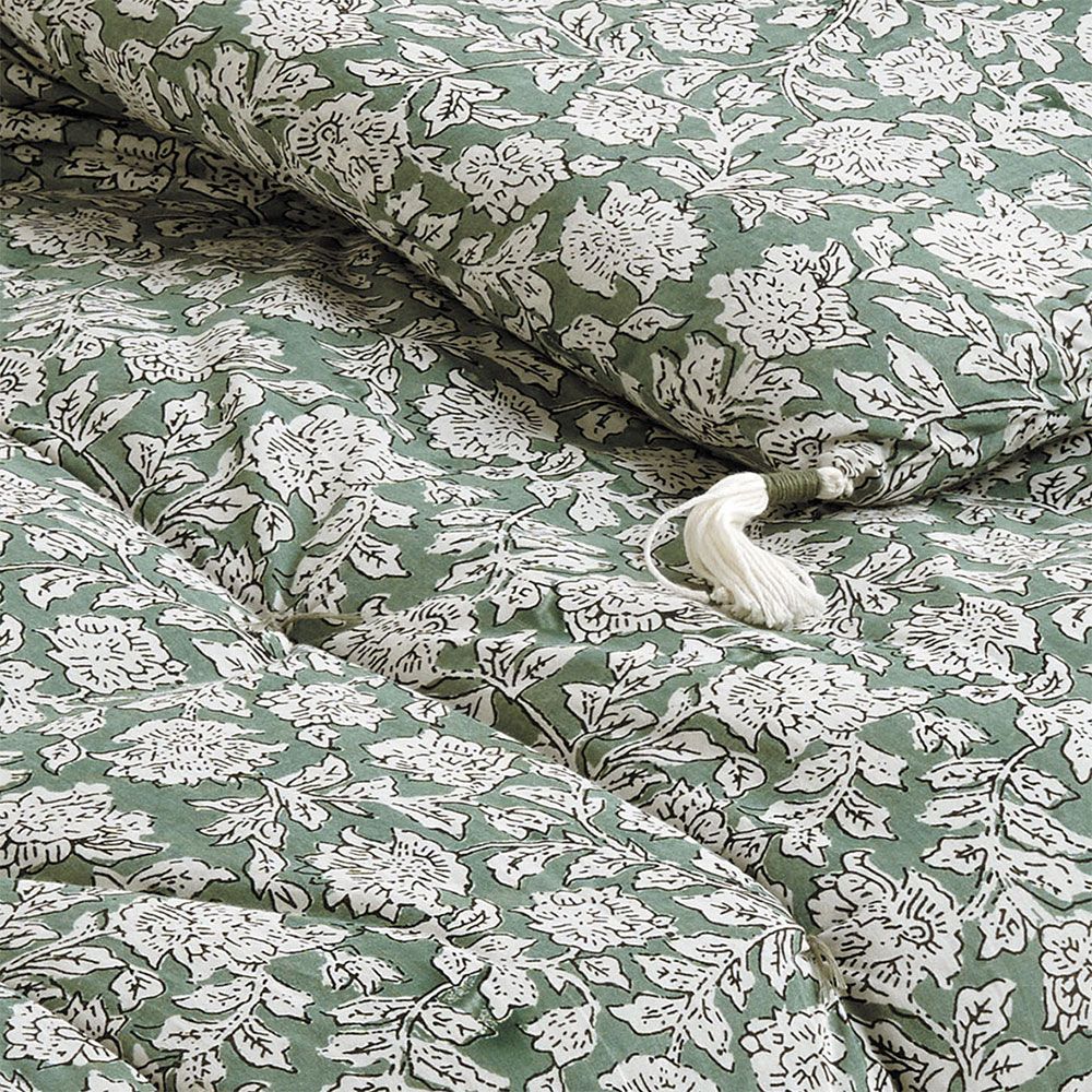 cosy quilt with floral details and tassels
