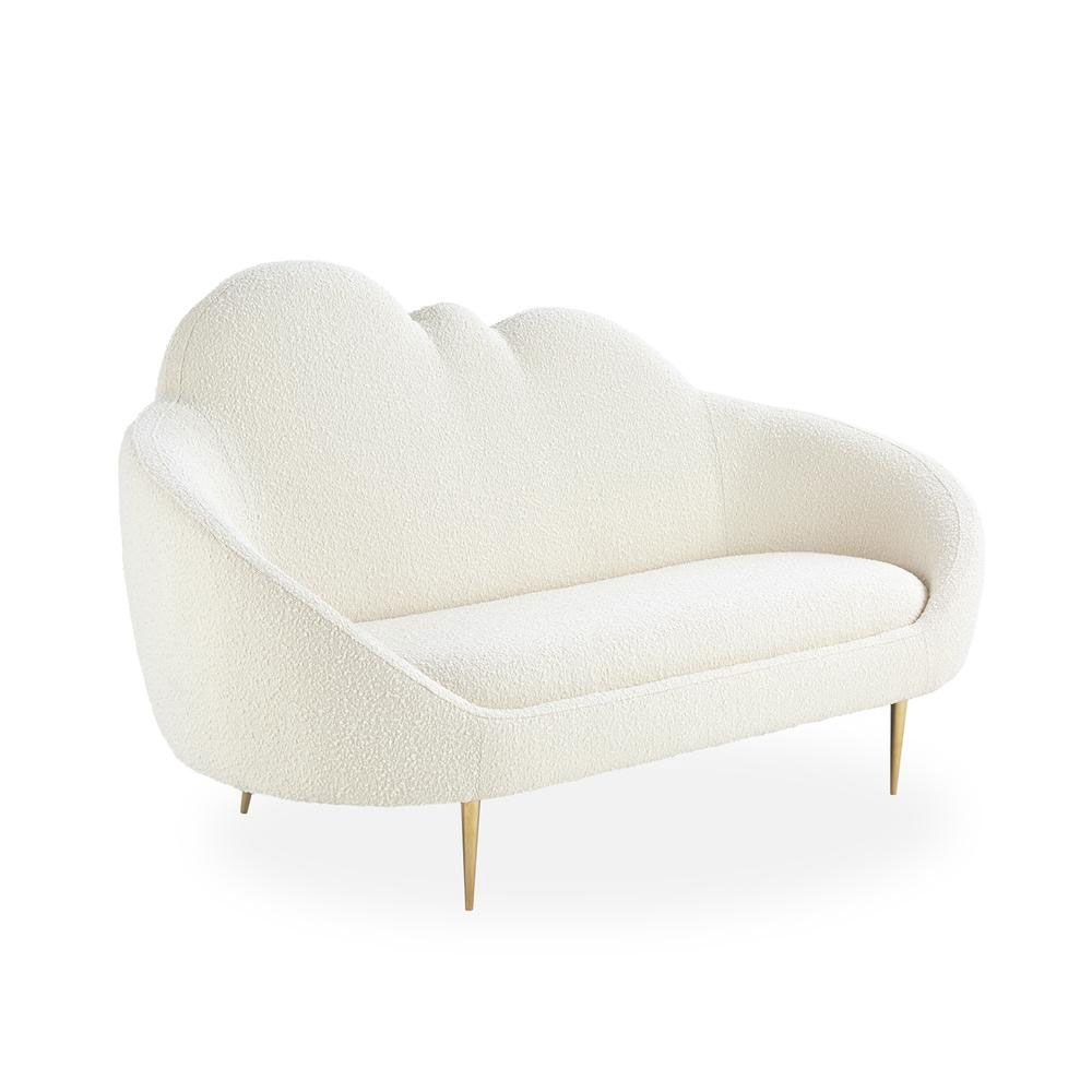 A luxurious cloud-shaped sofa with boucle upholstery and polished brass legs