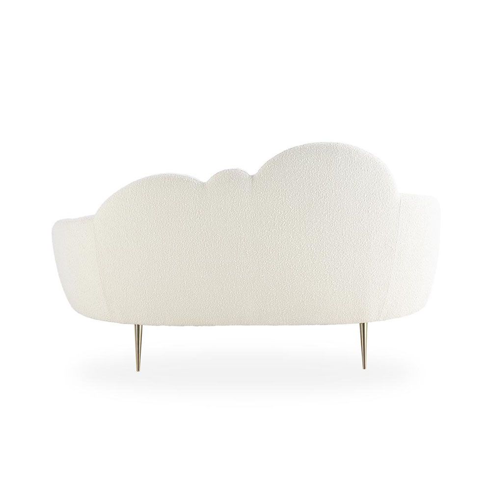 A luxurious cloud-shaped sofa with boucle upholstery and polished brass legs