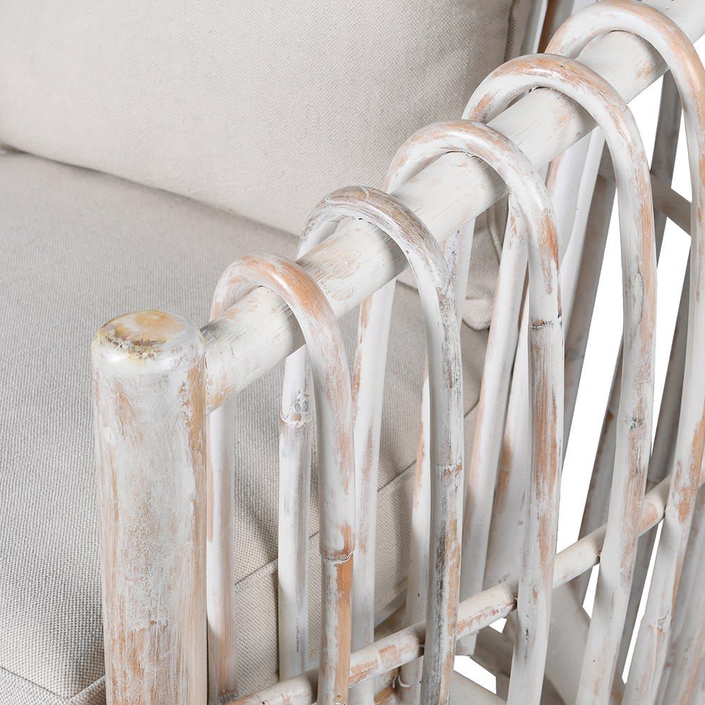 A distinctive and distressed whitewash armchair with a round structure and wooden ribs