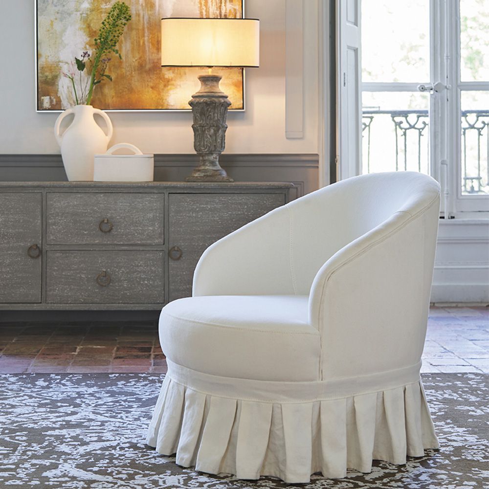 A luxurious, French-style off-white cotton and linen blend armchair with pleated fringing
