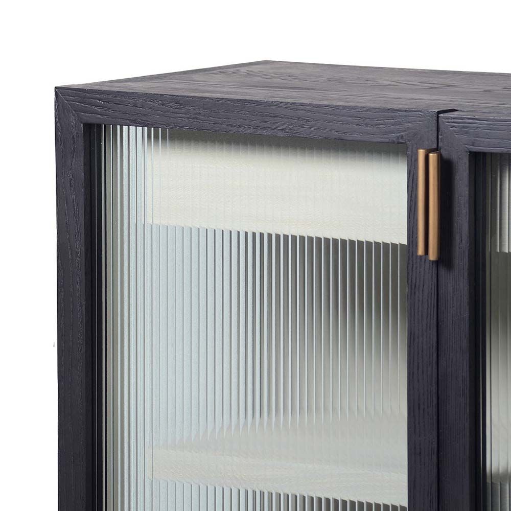 A luxe two door cabinet with two shelves, two drawers and brass hardware
