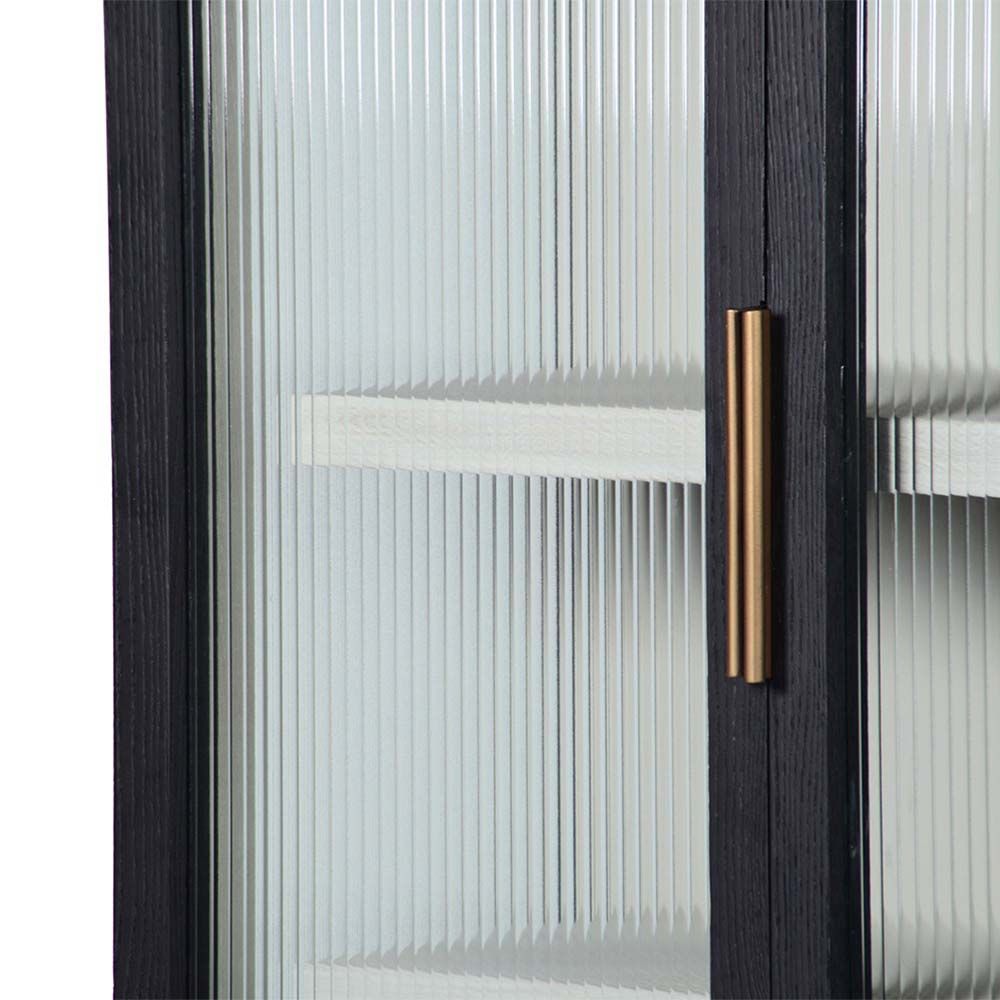 A decadent display cabinet with fluted glass doors and brass handles