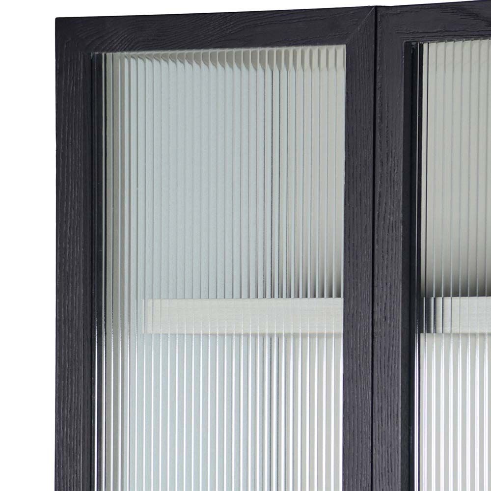 A decadent display cabinet with fluted glass doors and brass handles