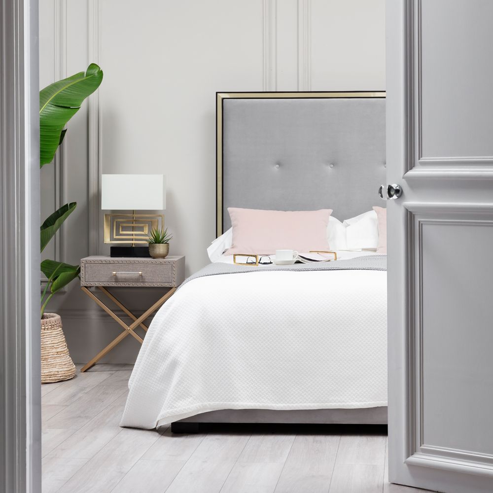 An upholstered bed with a buttoned headboard