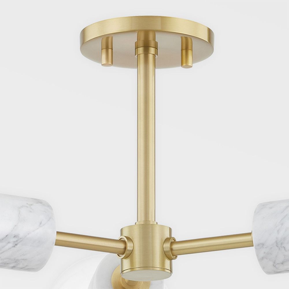 A glamorous aged brass ceiling lamp with glass lampshades and marble accents