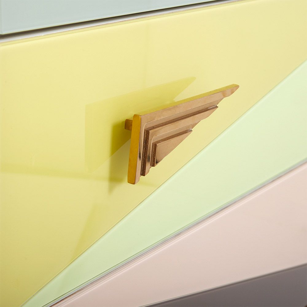 A modern Italian-inspired chest of drawers with angular hardware and brass accents