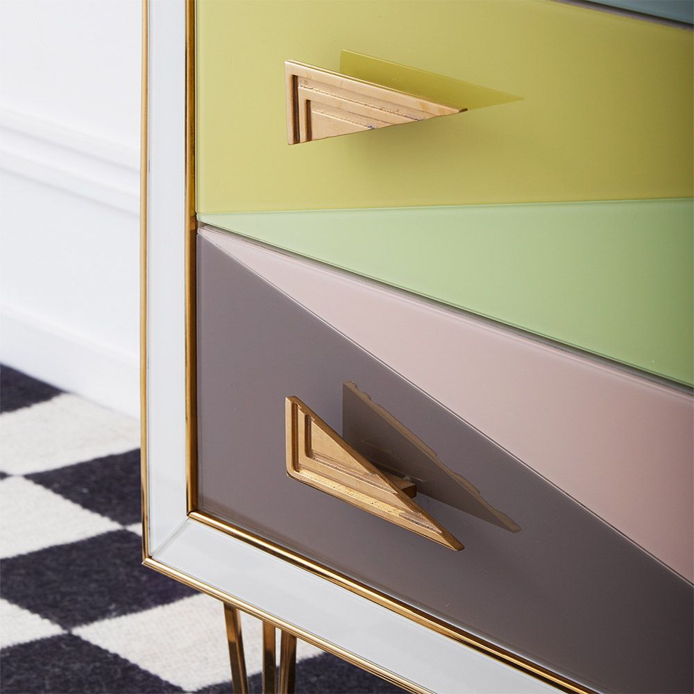 A modern Italian-inspired chest of drawers with angular hardware and brass accents