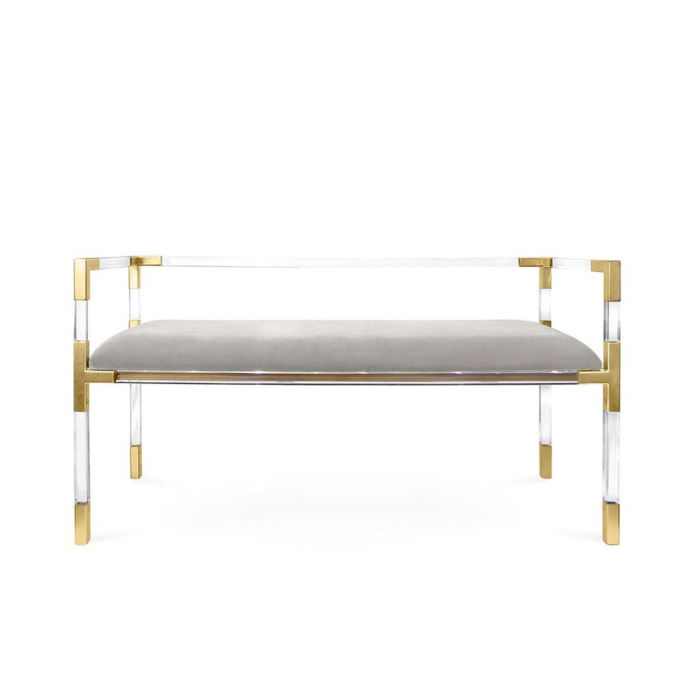 A chic grey velvet stool with an acrylic and brass frame