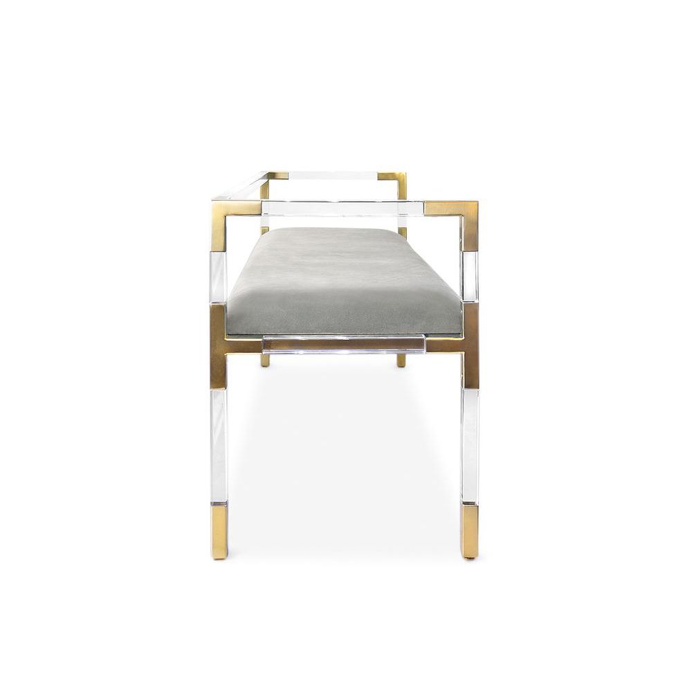 A chic grey velvet stool with an acrylic and brass frame